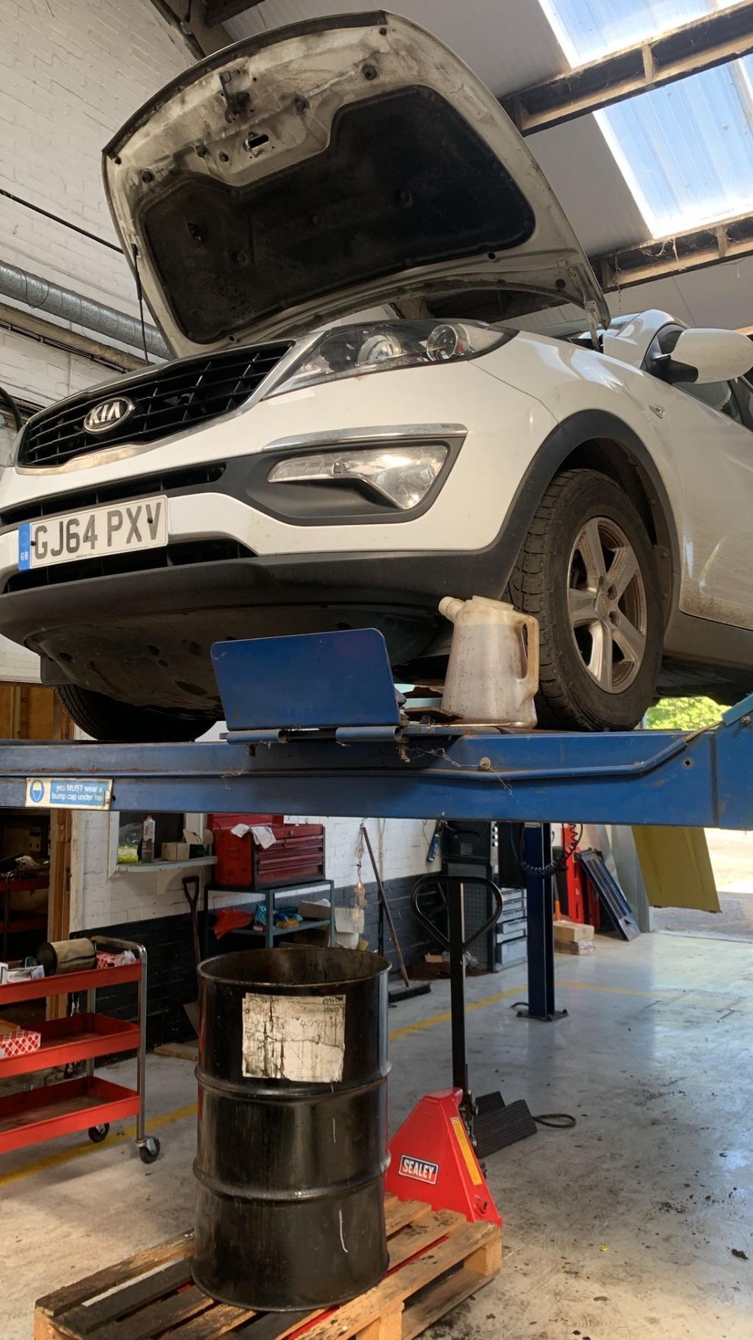 Kia Sportage raised on a two-post lift, bonnet up